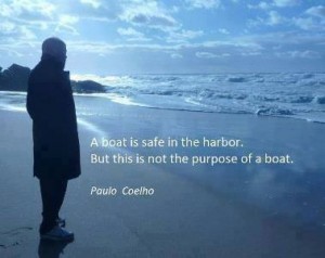 Silhouette of a person on a beach with the Paulo Coelho quote, a boat is safe in the harbor but this is not the purpose of a boat