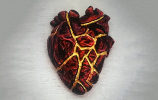 An anatomical heart mended with gold along its cracks, evoking kintsugi and healing from heartbreak