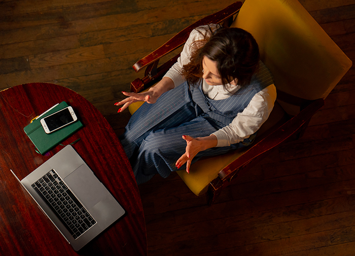 Child in a session, overhead view Overhead view of a child reclining and reaching out during a session, with a laptop and phone nearby