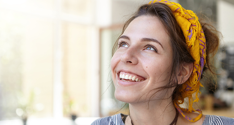 Joyful woman with yellow headscarf A woman wearing a yellow headscarf smiling joyfully