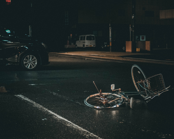 Crashed bicycle at night A twisted, crashed bicycle lying on a dark road at night, evoking accident and trauma