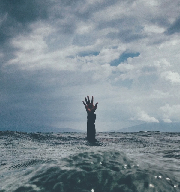 Hand reaching from the water A hand reaching up from turbulent ocean water, evoking drowning and a call to be saved