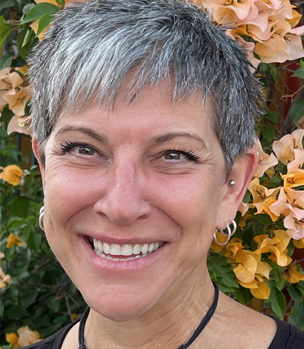 Portrait of Sabrina Santa Clara smiling Portrait of a Sabrina Santa Clara smiling with short gray hair among flowers