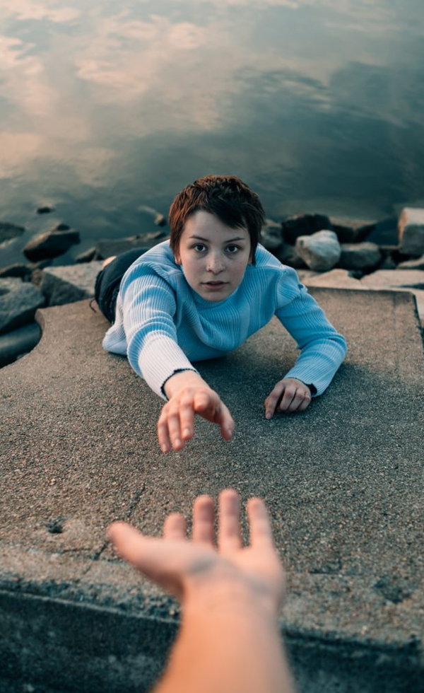 Reaching out a hand for help A person lying on the ground reaching a hand toward the viewer, evoking a call for help and connection