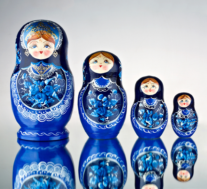A row of blue Russian nesting dolls from large to small, evoking the many layers or parts of the self