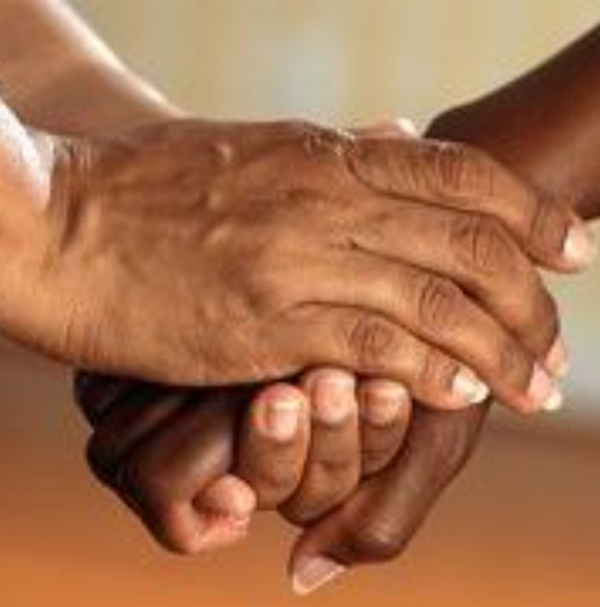 Two hands clasped in support A pair of brown-toned hands clasped together, one offering support to the other