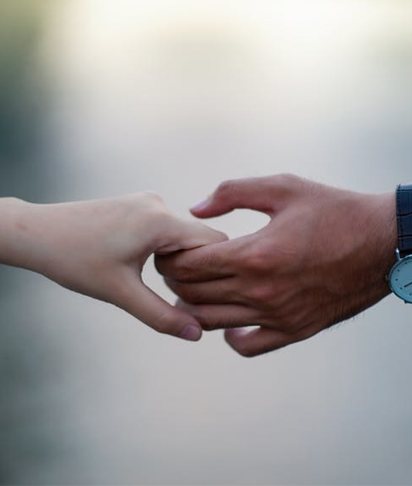 Two hands reaching to hold A lighter-skinned and a darker-skinned hand reaching to hold each other, evoking support and connection across difference