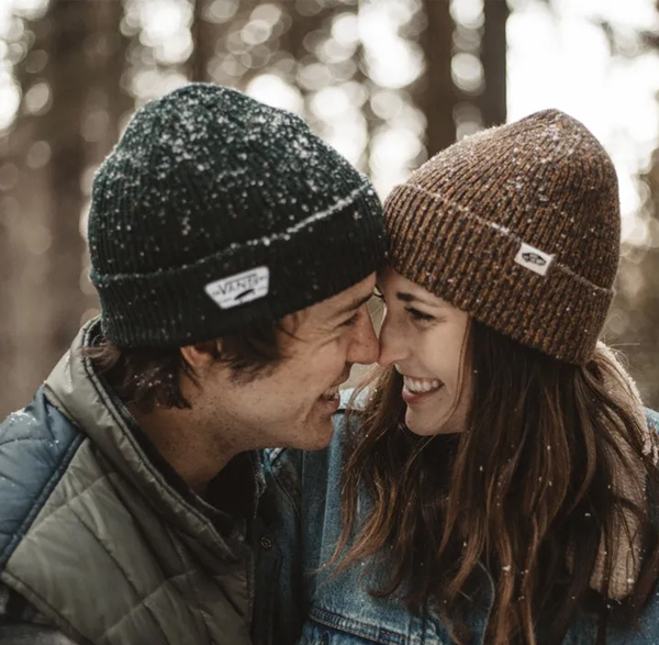 Couple touching noses in winter A smiling young couple in winter beanies touching noses tenderly, evoking love and connection