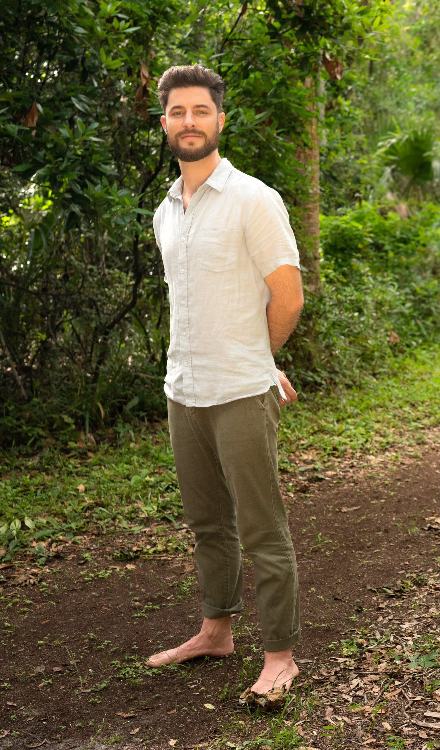 Matt Colaciello in the forest Matt Colaciello standing barefoot on a forest path, inviting forest walking