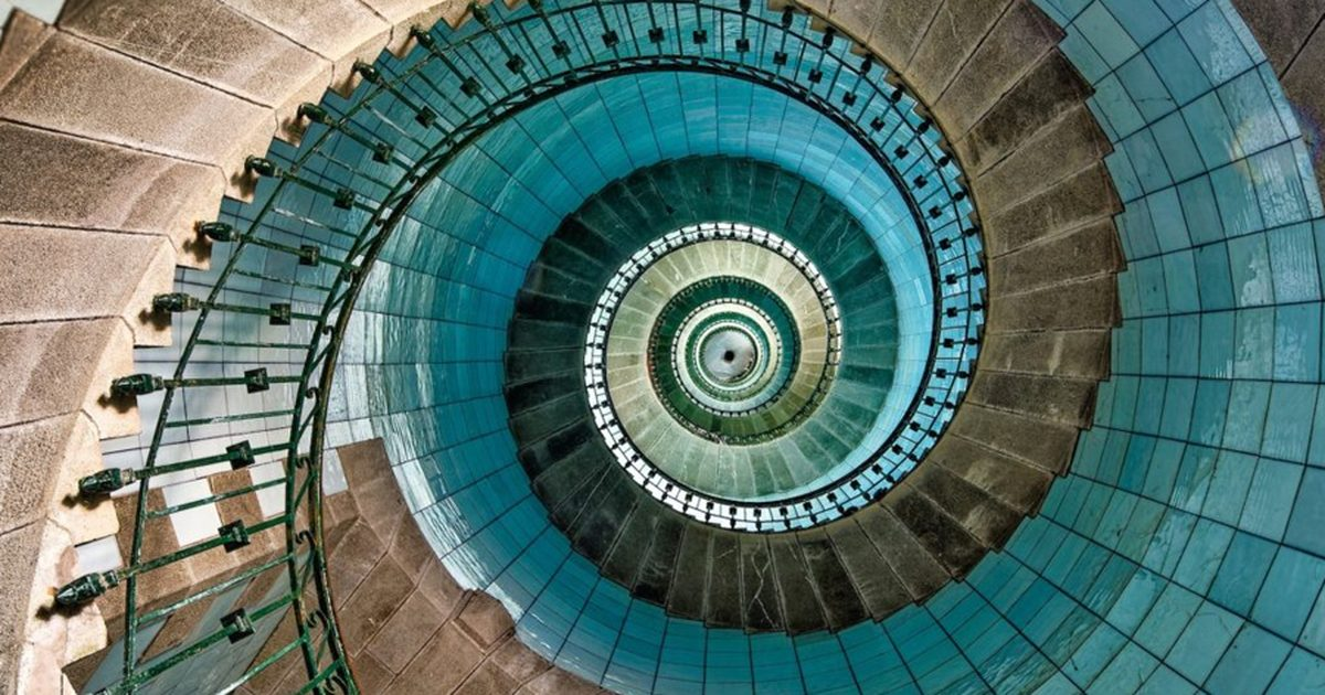 Looking straight down a spiral staircase to a small bright centre